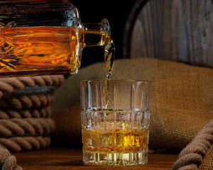 Glass and bottle of whiskey on rustic background