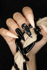 Beige and black manicure on long nails.