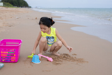 A young girl playing sand at the beach