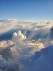 Aerial view of beautiful clouds formation in sunny day from plane