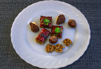 Natural sweet baklava with honey and nuts. Oriental sweets with nuts. Natural products on a plate. Walnut and chestnut fruits. Holiday Ramadan.