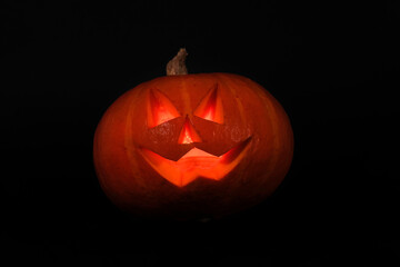 Funny Scary Halloween pumpkin with a candle inside isolated on black background. Scary smiling Halloween pumpkin DIY concept.