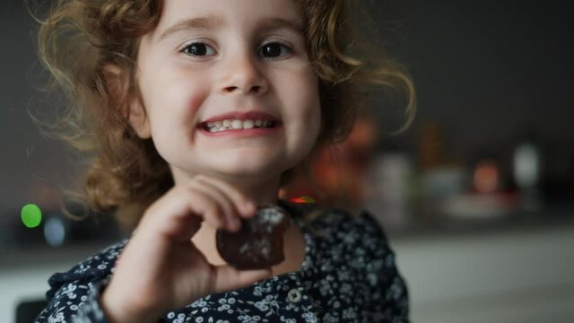 Little girl eating typical Christmas sweets, enjoying Christmas holidays. traditional Spanish Christmas food, polvorones and mantecados.