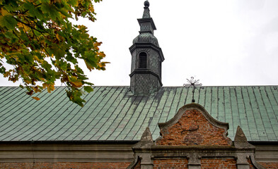 General view and architectural details close up of the belfry and the Catholic church of Saint Stanislaus the Bishop and Our Lady of the Rosary from 1507 in the city of Drobin in Masovia, Poland.