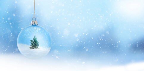 Sch&ouml;ne Weihnachtskugel aus Glas vor unscharfem Winterhintergrund