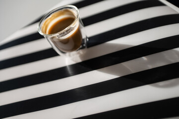 Photo of cup with black coffee and shadow on black and white background