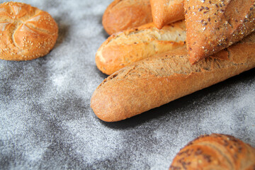 fresh baguettes with crispy crust, spices and seeds, spread on the table with a sprinkle of wheat...