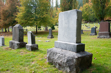 Old blank cemetery tombstones on a fall day.