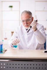 Old male chemist working in the lab