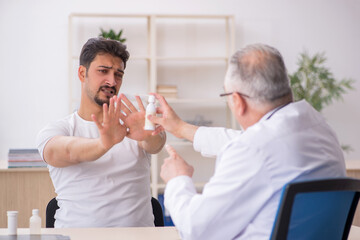 Young male asthamatic visiting old male doctor