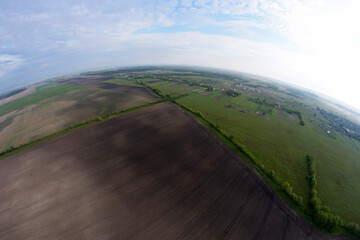 Top-view of an earth with fields and a typical farm from a basket of a hot-air balloon