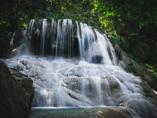 Obraz premium Scenic view of Erawan Waterfall. Epic smooth flowing water stream from limestone cliff in lush rainforest. Kanchanaburi, Thailand. Long exposure.