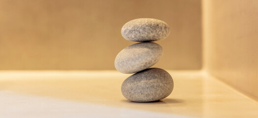 Fototapeta na wymiar Zen stones, smooth pebbles pyramid stacked balance, interior wall and floor background.