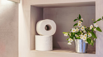 Toilet paper rolls on a bathroom wall shelf closeup view. Modern restroom interior detail