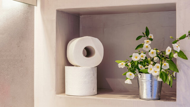 Toilet Paper Rolls On A Bathroom Wall Shelf Closeup View. Modern Restroom Interior Detail