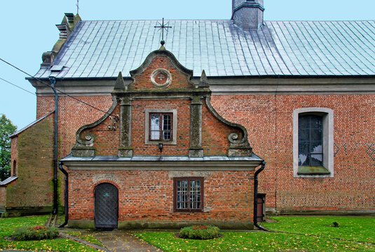 General view and architectural details close up of the belfry and the Catholic church of Saint Stanislaus the Bishop and Our Lady of the Rosary from 1507 in the city of Drobin in Masovia, Poland.