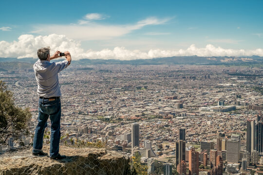 12-28-218. Bogotá, Colombia. A tourist take pictures of the city with smartphone along the pathway to Monserrate.