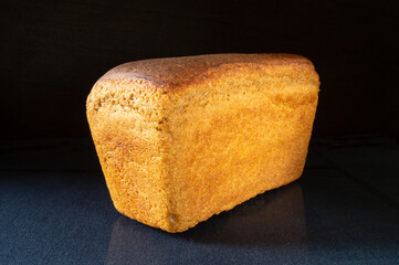 Aiming loaf of bread on turn blue the table with reflection.