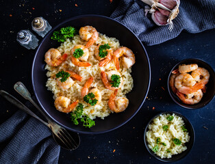 Risotto with prawns, chili and parsley on wooden table

