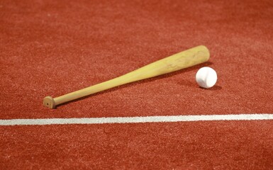 Baseball and baseball bat on turf