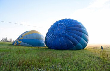 Obraz premium Hot-air balloon preparing for flight in a field