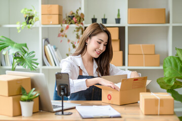 Beautiful young Asian business owner are packing order for customer. Online selling business.