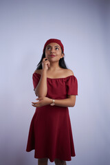 Mujer latina morena de pelo negro con vestido rojo navide&ntilde;o y gorro rojo sobre fondo blanco