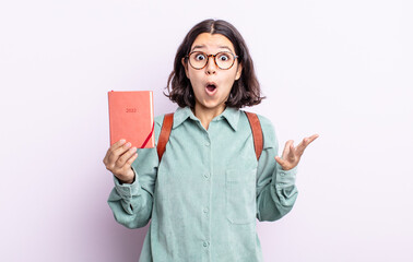 pretty young woman amazed, shocked and astonished with an unbelievable surprise. 2022 agenda concept