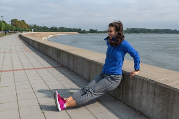 Young sweaty active fitness athletic  woman doing dips exercise for triceps and biceps muscle outdoor as workout and training for arm muscles in the autumn morning, female sport and recreation concept