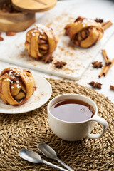 Fresh vegan cinnamon buns on marble board and white marble table