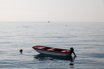 White power boat stops at the port Small motor boat on a calm silent sea Reflections Motorized boat and sea at sunset in turkey.