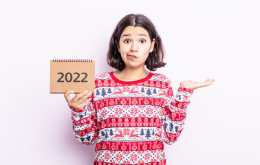 pretty young woman feeling puzzled and confused and doubting. 2022 calendar concept