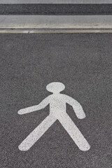 Walking pedestrian crossing sign painted in white on the ground