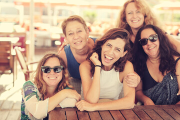 Women best friends sitting in summer cafe on the beach