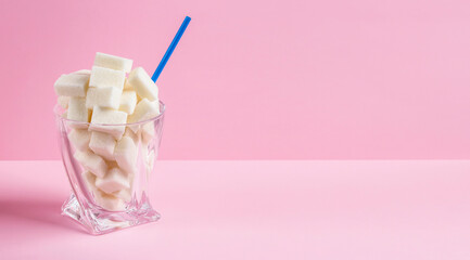 Sugar cubes in a glass with a straw. Dangerous food.