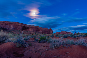 Moon lite desert scene with blurry clouds