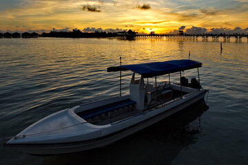 Fototapeta premium Malaysia. The east coast of Borneo. A blazing dawn on the reef island of Mabul, famous all over the world for its diving clubs.