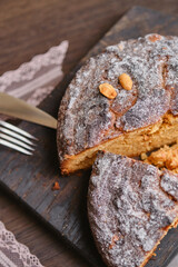 Fresh perfect bundt cake or muffin cake consisting of peanut decorated icing sugar on the wooden cutting board. Christmas cake in Germany traditional pastries Christstollen.  Shallow depth of field