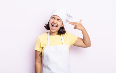 pretty young woman looking unhappy and stressed, suicide gesture making gun sign. chef concept