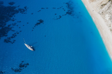 Lefkada, Greece. Remote white Egremni beach with lonely luxury yacht boat on the turquoise colored bay on Ionian Sea