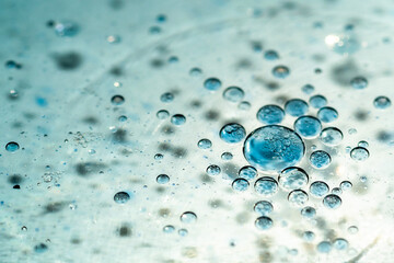 White and blue waterdrops swimming on a oil surface