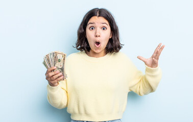 pretty young woman amazed, shocked and astonished with an unbelievable surprise. dollar banknotes...
