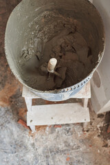 Fresh cement bucket with trowel to work