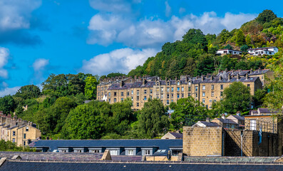 A view of terrace buildings on the valley side of Hebden Bridge, Yorkshire, UK in summertime - obrazy, fototapety, plakaty