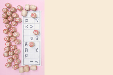 Card for playing lotto or bingo and many wooden barrels with numbers. Beige and pink background...