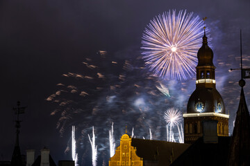 Riga cathedral from the 13th century with fireworks in the background at night. Latvia.