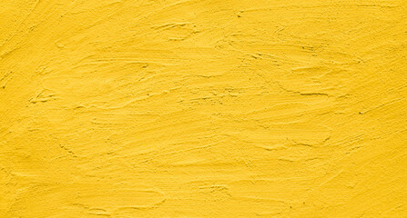 Artistic creative vibrant yellow stucco wall background