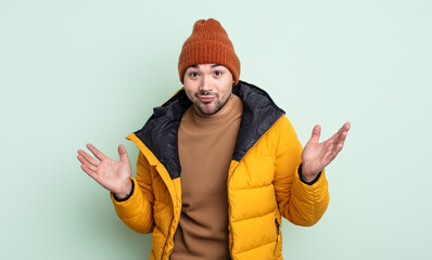 young handsome man feeling puzzled and confused and doubting. cold weather concept