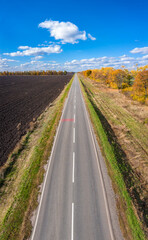aerial view to road in a autumn field