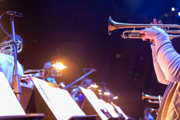 Trumpet players in a big band section with moody lighting